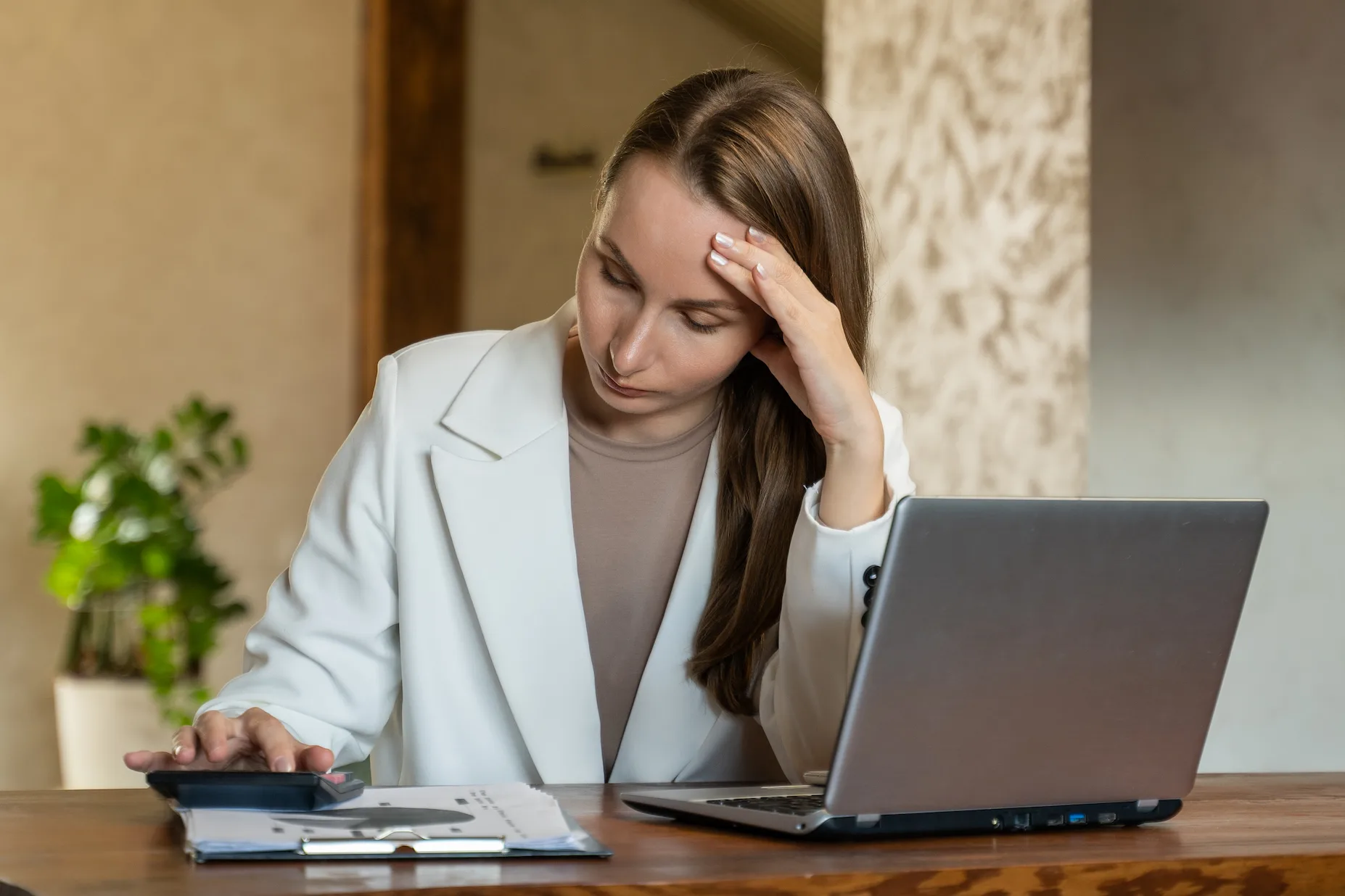 Lonely woman experiencing huge debt infront of a calculator